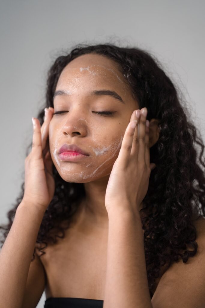 A serene moment of a young woman cleansing her face with facial wash in a skincare routine.