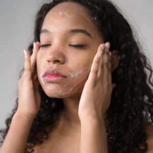 A serene moment of a young woman cleansing her face with facial wash in a skincare routine.